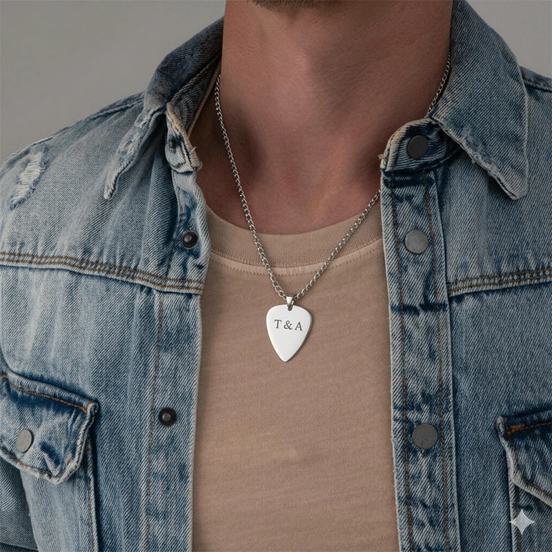 Person wearing a denim jacket and beige shirt with a necklace featuring a heart-shaped pendant.