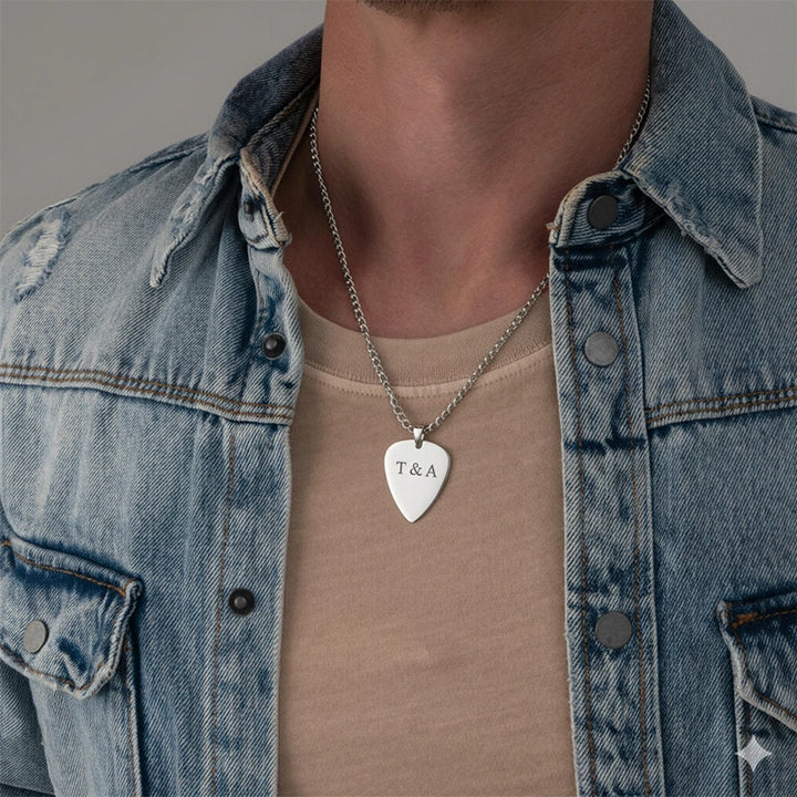 Person wearing a denim jacket and beige shirt with a necklace featuring a heart-shaped pendant.