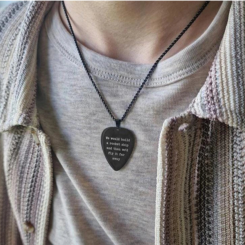 Person wearing a necklace with a heart-shaped pendant on a plain background